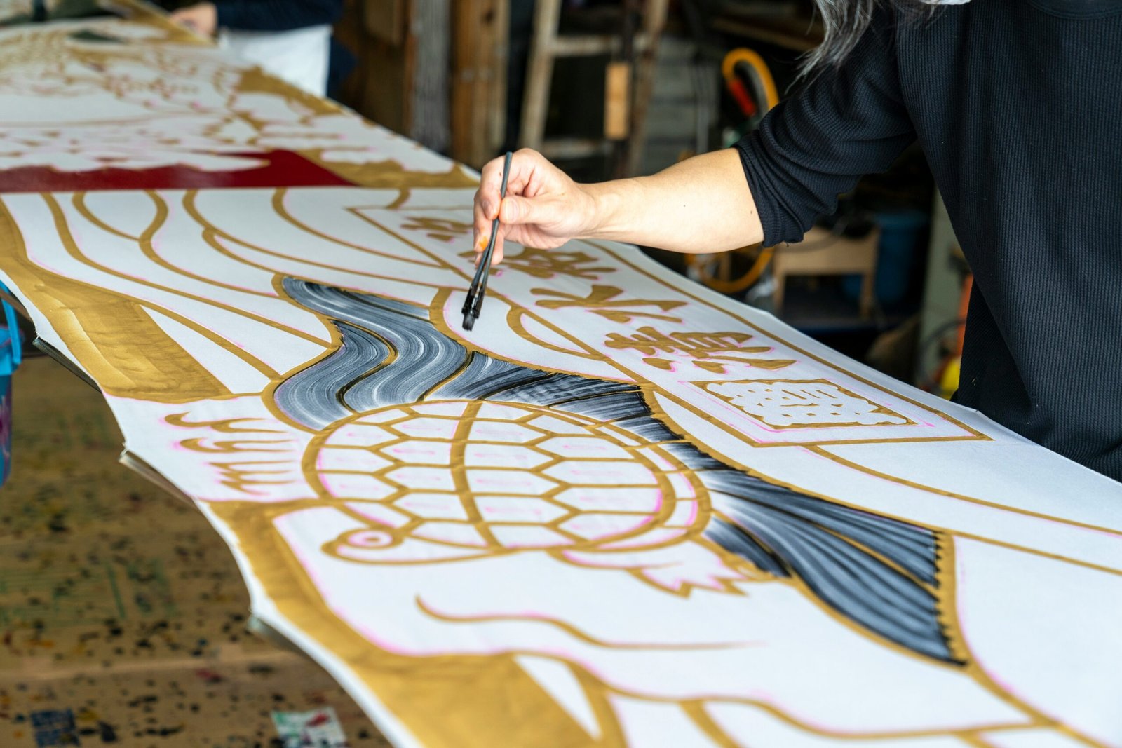 a woman is working on a large piece of art